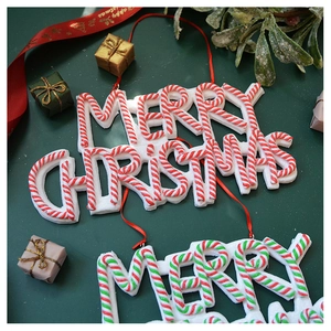 Macro shot of Merry Christmas candy stripe ornaments with glitter finish for festive decor