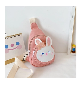 Detail of pink canvas chest bag featuring a cute white rabbit patch and glitter accents