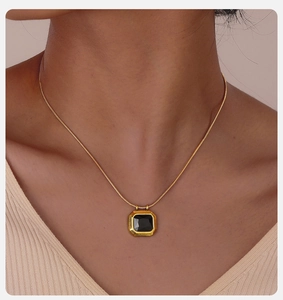 Detailed view of a gold-plated stainless steel snake chain with a square black gem pendant