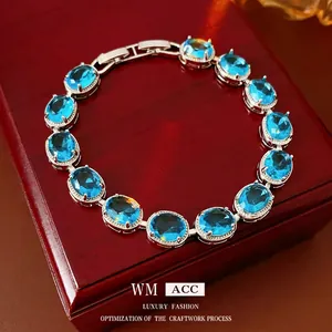 Elegant silver bracelet featuring oval blue zircons set on a dark wood jewelry box