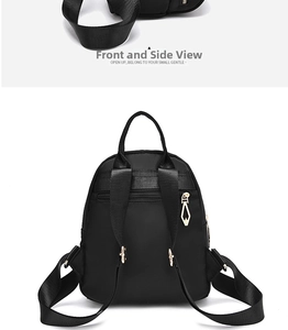 Detail view of black oxford backpack showing gold metal zippers and back anti-theft pocket