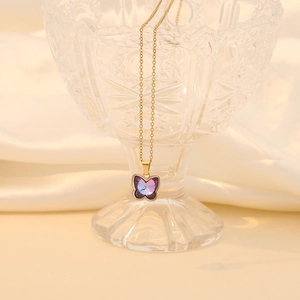 Detailed close-up of a gold necklace featuring a purple crystal butterfly pendant design
