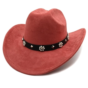 Détail d'un chapeau de cow-boy en daim rouge brique avec bandeau en cuir clouté et perles