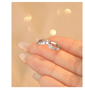Detail of s925 silver star ring with zircon stones worn on hand in a soft lighting scene