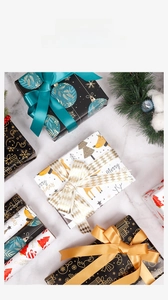 Detail of Christmas gift wrapping paper with reindeer patterns and ribbons on marble background