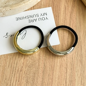 Close-up of minimalist gold and silver alloy curved metal buckles on high-elastic hair ties