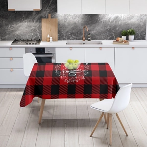 Red and black checkered Christmas tablecloth with white festive print on a dining table