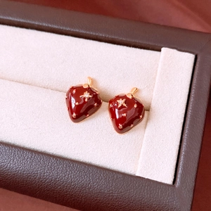 Close-up of strawberry stud earrings with red enamel and sparkling zircon detail
