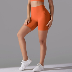 Close-up of bright orange high-waisted yoga shorts with seamless high-elastic fabric