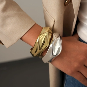 Polished gold and silver irregular wave cuff bracelets with a minimalist fluid design
