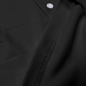 Close-up of black breathable mesh fabric with a white button and reinforced stitching