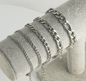 Vista detallada de cadenas de acero de titanio plateado en cinco anchos sobre soporte
