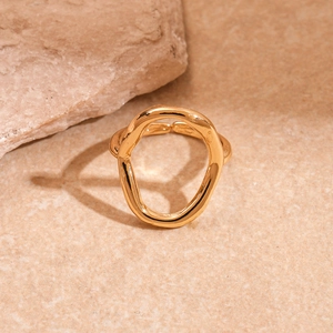 Macro shot of irregular lava style gold ring on stone with organic flowing texture