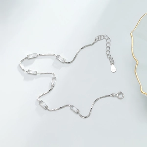 Macro shot of S925 sterling silver chain featuring rectangular clear zircon gemstones