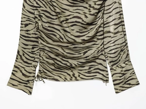 Detail der Zebra-Bluse mit verstellbarem Kordelzug an der Seite und geknöpften Manschetten