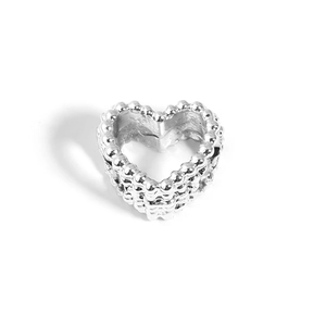 Detailed macro view of silver heart-shaped metal bead with intricate woven texture
