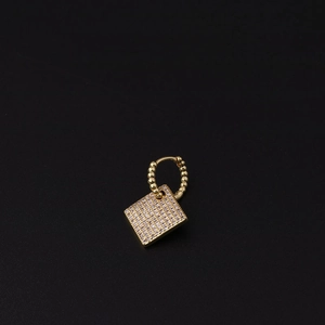 Detail view of a gold-plated hoop earring featuring a pavé-set square zircon charm pendant