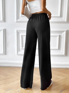 Rear view of black high waist wide leg pants with elastic waistband on model