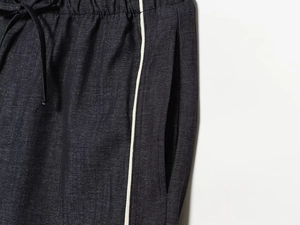 Détail du jogging gris avec taille élastique à cordon et bandes latérales blanches