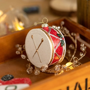 Festive red and white drum Christmas ornament with holly leaf detail and gold glitter finish