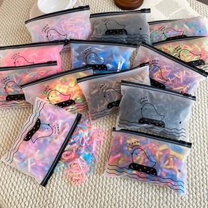 Macro shot of colorful high elasticity hair ties in a frosted zipper bag on a white rug