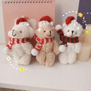 Close-up of three cute plush teddy bears wearing festive Christmas hats and scarves