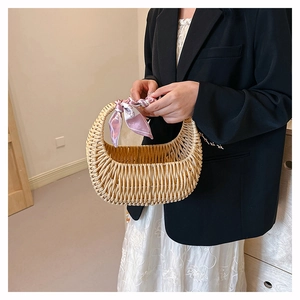 Detail of hand-woven rattan basket bag decorated with a stylish pink floral silk scarf