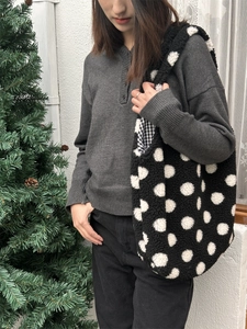 Sac seau en peluche à pois blancs avec texture douce en polaire porté par un mannequin