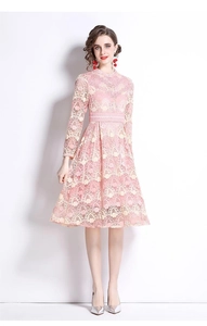 Détail de broderie en dentelle rose sur robe trapèze avec manches longues fleuries