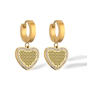 Close-up of gold-plated heart pendant earrings with zircon stones on white backdrop
