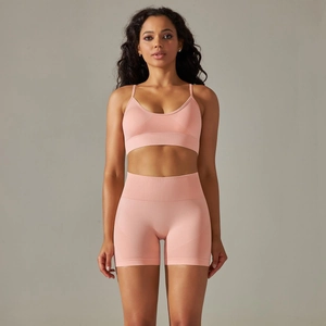 Front view of seamless pink peach yoga set with V-neck sports bra and high-waist shorts