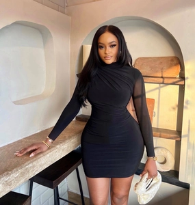 Detail of slim fit black mini dress featuring mesh long sleeves and side ruching texture