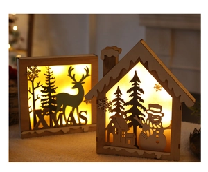 Detail of wooden Christmas lantern with warm LED light featuring reindeer and snowflake cutouts