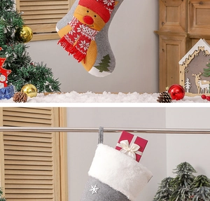Detail of gray Christmas stockings with reindeer embroidery and white faux fur trim decor