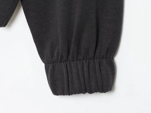 Detail view of dark grey ribbed knit cuffs and soft cotton fabric texture on tracksuit