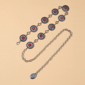 Close-up of bohemian silver chain belt featuring red stone discs and intricate engraving