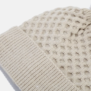 Detailed macro view showing the honeycombed knitting and ribbed edge of winter hat