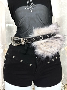 Détail de la ceinture à paillettes noires avec fausse fourrure blanche et boucle strass