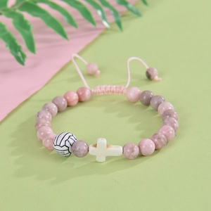 Detail of pink marble beads with volleyball and white cross charms on adjustable cord