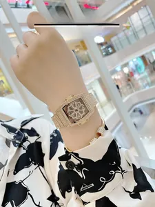 Detail of tonneau gold watch with rotating clover dial and crystal bracelet