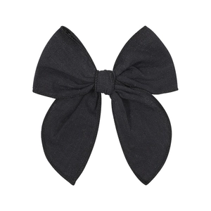 Detailed macro view of black woven cotton bow clip showing fine fabric texture and weave