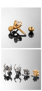 Détail de boucles d'oreilles crâne et araignée en acier inoxydable avec fermoir à vis sur miroir