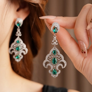 Nahaufnahme von Vintage-Silberohrringen mit grünen Edelsteinen für einen Luxus-Look