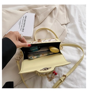 Top view of yellow crossbody bag interior showing storage space for phone and makeup