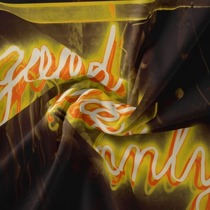 Detail of bohemian tapestry fabric showing glowing good energy text on dark background