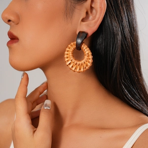 Close-up of bohemian round rattan drop earrings with tortoiseshell resin connectors