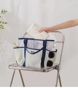 White mesh beach bag with pockets and blue handles showing storage capacity and details