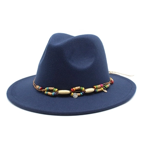 Détail d'un chapeau fedora bleu marine avec ruban décoratif à perles colorées ethniques