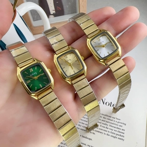 Detailed shot of three square women watches with gold alloy bands in green gold and white