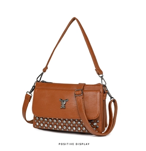 Detail of brown PU leather handbag featuring a metal rabbit logo and bottom studs